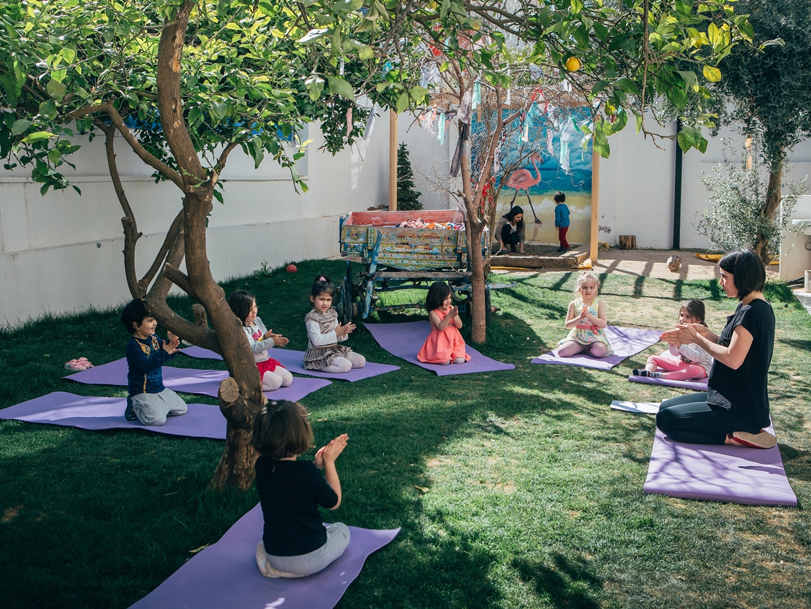 Limon Montessori bahçesinde minderler üzerinde grup yoga çalışması