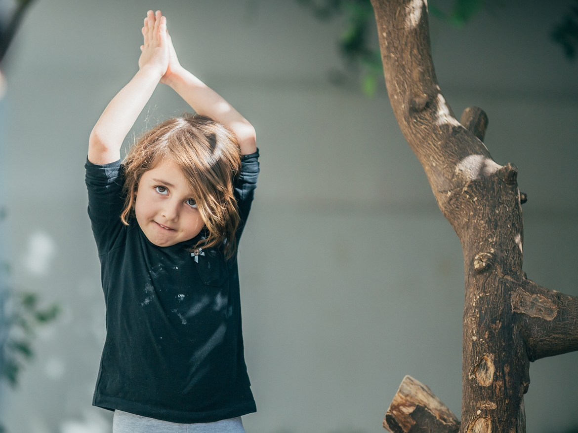 Limon Montessori bahçesinde ellerini başının üzerinde birleştirerek hareket çalışması yapan çocuk